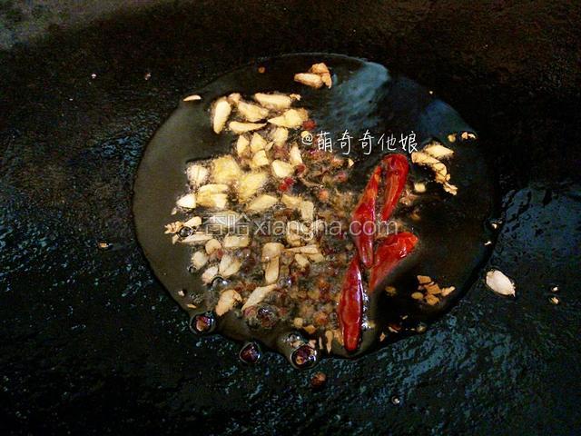 锅中倒油烧热下大蒜碎、花椒粒、干辣椒小火煸炒出香味。
