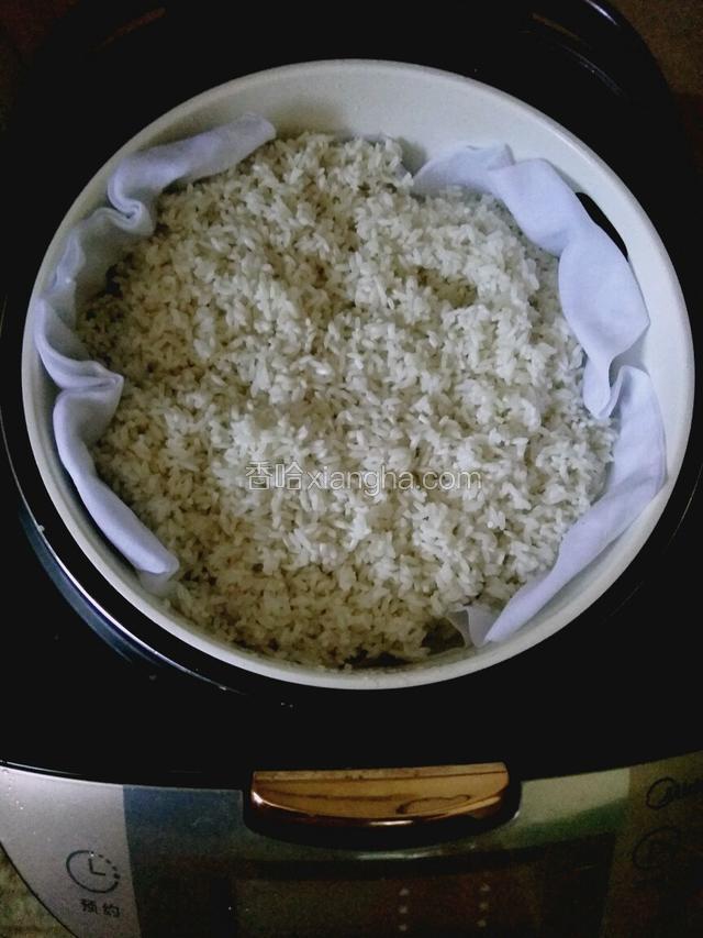 糯米放入蒸盘蒸，蒸盘上面铺块布，我用的是隔渣袋。隔水蒸，我按的是汤／粥键，2小时。