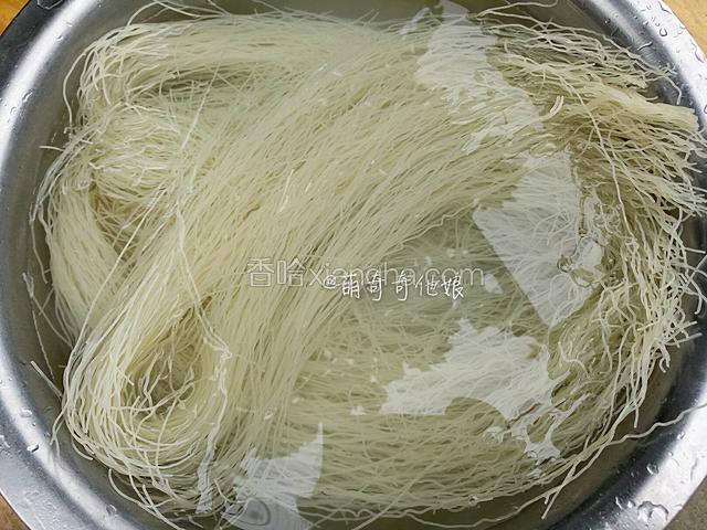 用冷水浸泡至软，如果盆太小装不下也不要把米面折断，可以慢慢压在水里变软后再把边缘压下去即可。

（如果用的挂面则省略此步骤，直接锅中烧开水，下挂面煮至六七成熟后捞出过冷水拨散后沥水即可，煮好的面条内芯应该大部分都还是白色的，别煮太熟。）