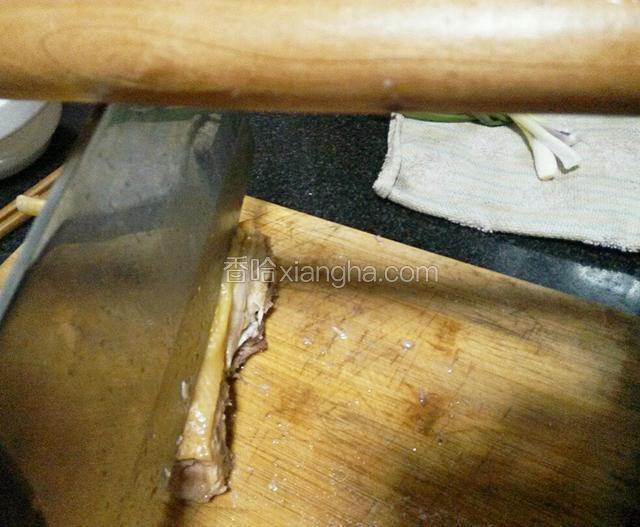 将冷却的鸡放在菜板上，刀放在即将切的地方，另一个人用擀面杖用力敲打刀背，使鸡肉切开