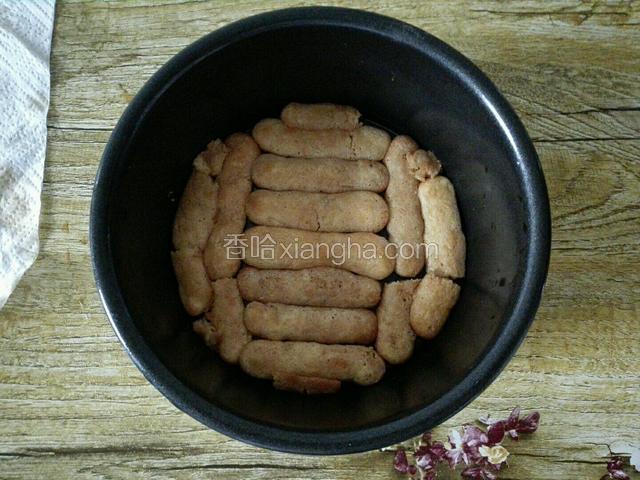把手指饼干分块沾匀咖啡蜜酒，然后铺平模具底部