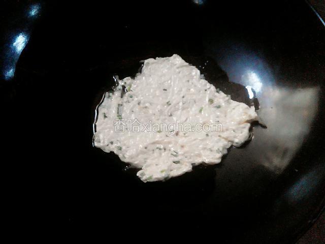 锅中加少量的油放入搅拌好的面浆，用铲子压平
