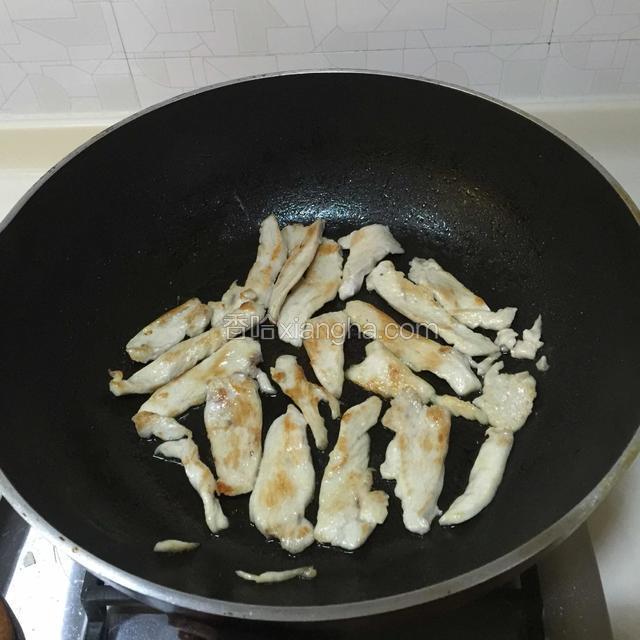 锅中倒入适量橄榄油，放入鸡胸肉小火煎至两面变黄