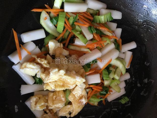 青菜、胡萝卜、鸡蛋全部加入跟年糕一起翻炒，加适量盐