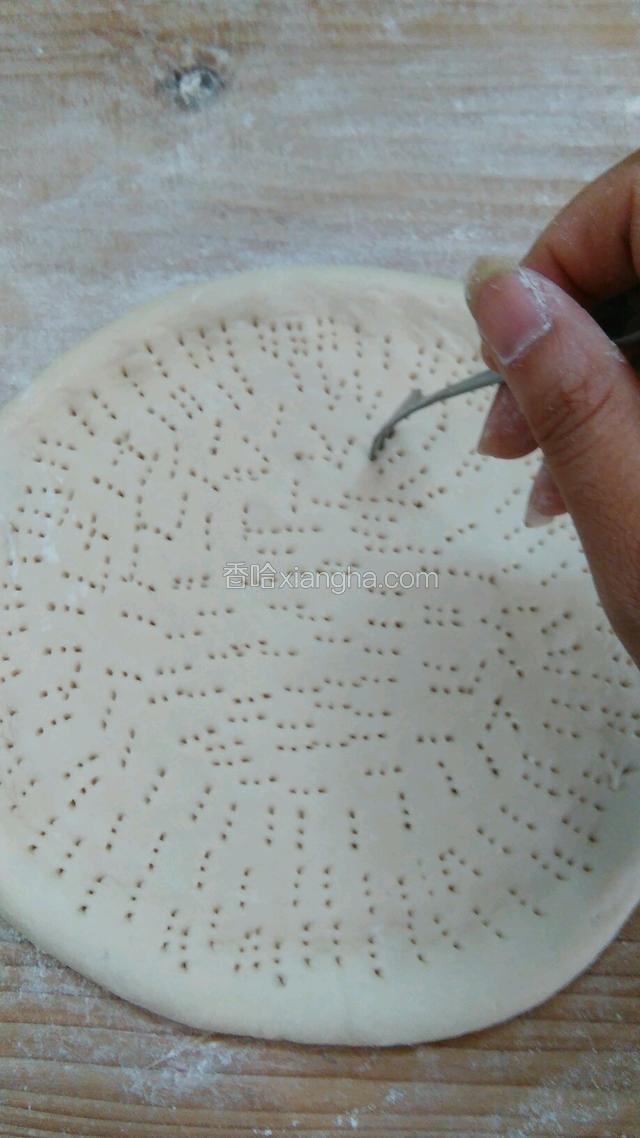 用叉子在面饼上扎上小眼。