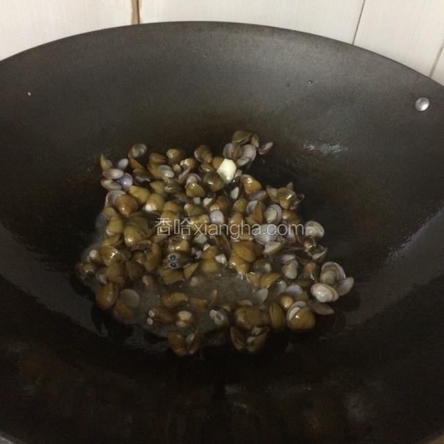 锅里倒入适量的油，大火烧热，放入蒜粒爆香后迅速倒入蚶子入锅爆炒。