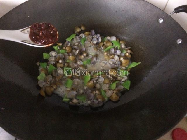 青辣椒炒均后倒入豆瓣酱，少许料酒，和少许白糖，翻炒均匀，会出来许多汤汁。