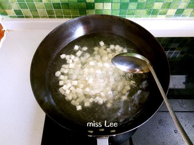 重新起锅，添入两大碗清水，大火滚开后先下入豆腐煮开，继而转小火煮沸5分钟；