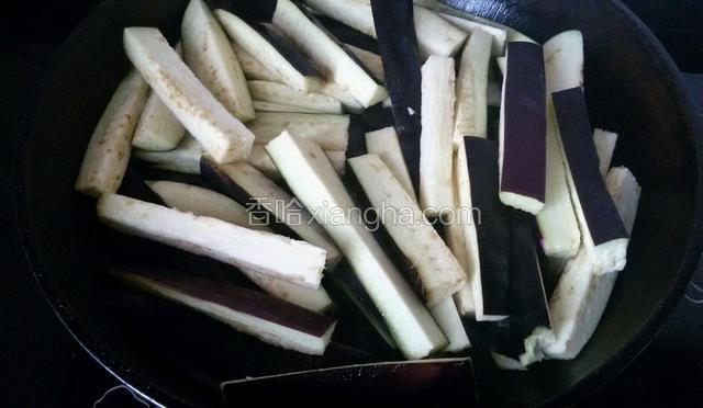 平底锅里放花生油，油热以后，放茄子进去。