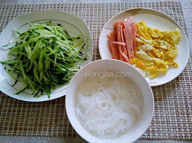 粉丝开水绰过捞出，鸡蛋烙成饼切丝，黄瓜和火腿切丝备用
