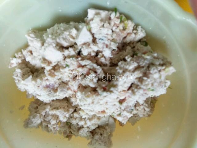把老豆腐捏碎加入猪肉馅中，加盐，鸡精搅拌均匀