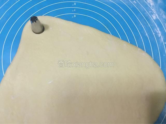 把面团擀成1.5厘米厚的面片，接着用中号或大号裱花嘴按压在面片上