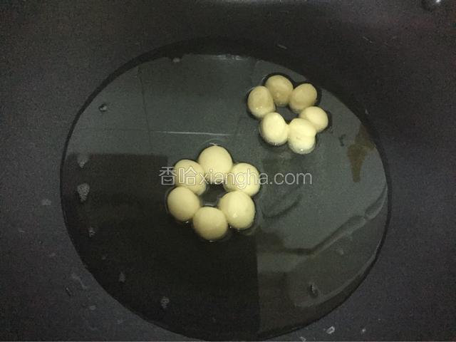 锅中倒入油烧至六七成热时放入甜甜圈，中小火炸至金黄色