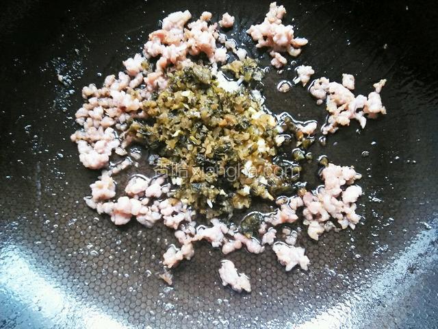 炸花生米的油留在锅中，倒入肉沫炒香后加碎米芽菜和姜蒜末