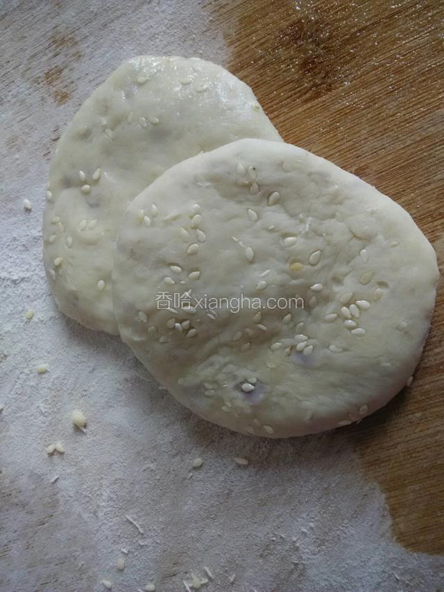 把小剂子揉圆按扁两面沾上白芝麻。