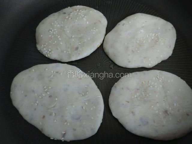 把做好的茄饼胚摊进锅里小火煎制。