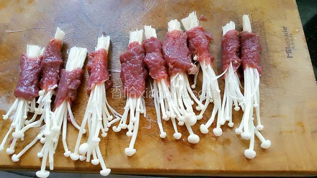 牛肉片用嫩肉粉和盐腌制10分钟，把金针菇卷起来捏紧