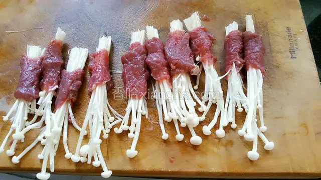 牛肉片用嫩肉粉和盐腌制10分钟，把金针菇卷起来捏紧