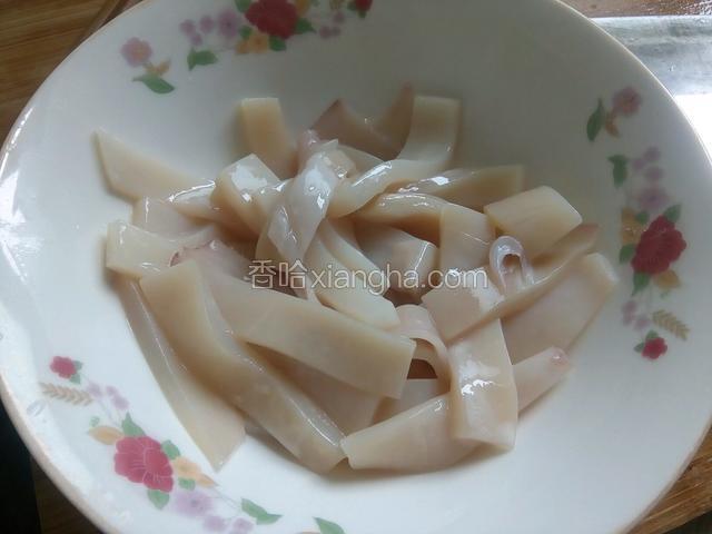 鱿鱼撕去黑衣，洗净在鱼上斜切三分之一深斜口，再切条，用料酒，一点盐，淀粉搅拌均匀腌制10分钟