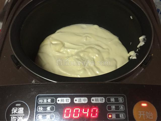 倒入预热好的电饭煲中，用刮刀把表面抹均匀。盖上盖子，切换蛋糕功能