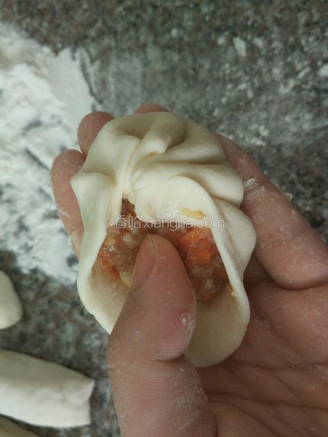 再把肉馅放中间，用右手先折起一个褶子，再折第二个褶子，将两个褶子在顶部粘合在一起，然后依次折下去，最后一个褶子折好，与起头处粘在一起，呈现碗口状，中间用大拇指往下稍稍按一下，轻轻给包子整整形即可。