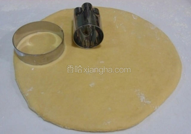 发酵好的面团排气松弛15分钟后擀成圆形，用工具压出甜甜圈的造型