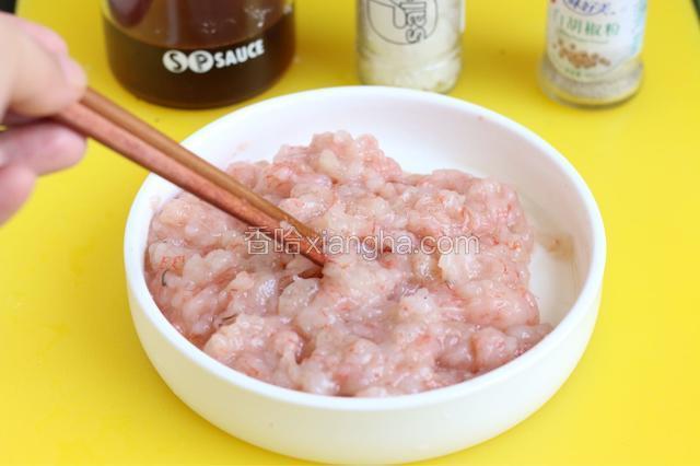虾仁中加入白胡椒、2克盐、一汤匙料酒、一汤匙生粉抓匀腌制片刻，然后加入胡萝卜。最好再加入一勺生油封住虾的鲜汁水份。