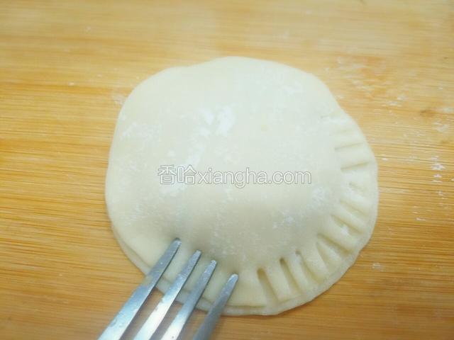 用刀叉将两张饺子皮按严实，并且饺子皮的两面都按出花边来。
