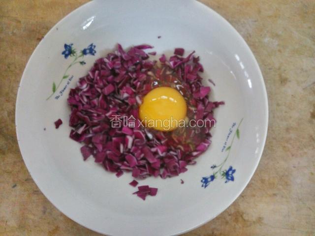 把紫甘蓝碎放碗里，加一个鸡蛋拌匀