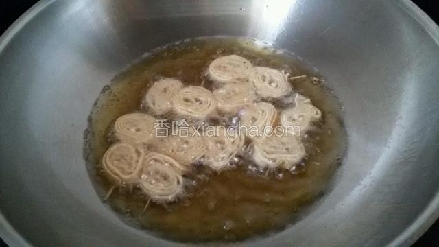锅中花生油，油温四五层热时放入豆腐皮。