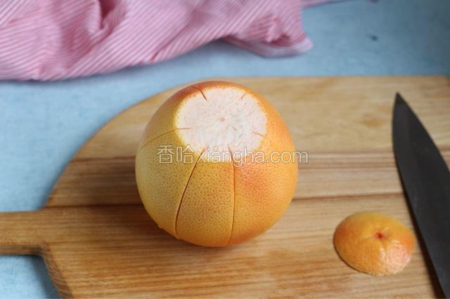 先将西柚顶部切去，用刀将皮上由顶到底划出六刀竖线，如图。别切太深切到果肉。