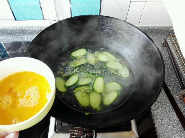 然后把鸡蛋液淋入锅中