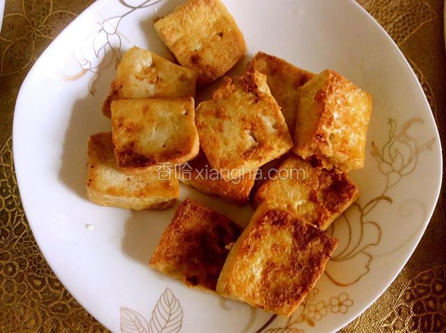煎好的豆腐泡放入盘中