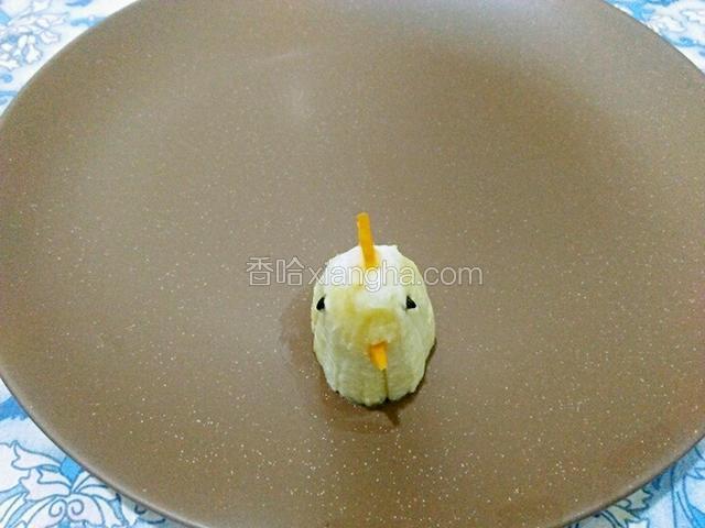 把香蕉头用胡萝卜和黑米粒装饰成图上的样子，放在一边备用。