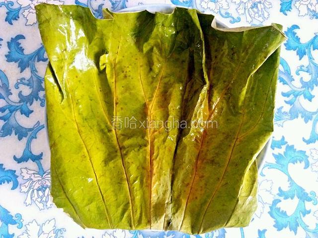 干荷叶提前泡一下，准备一个盘子，将荷叶的三分之二铺在盘子上。