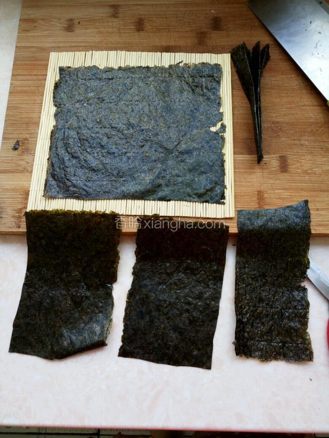 紫菜一张铺好,另一张根据眼睛和嘴剪好,嘴巴折好