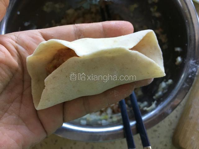 饺子皮对折，上下捏紧。
