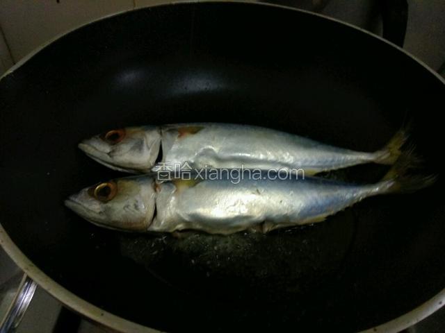 热油锅放鲅鱼入锅煎，一面金黄翻另一面