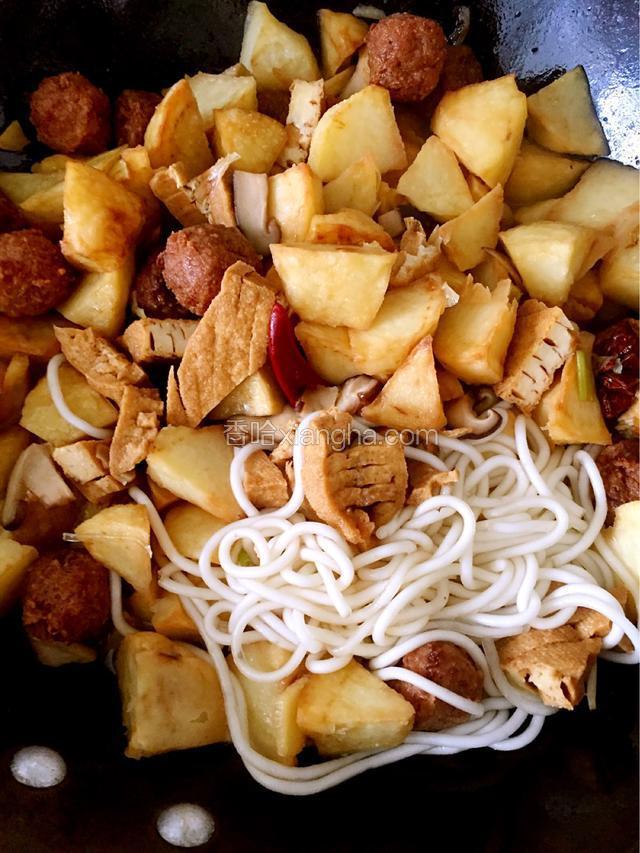 放入炸好的土豆，油豆腐翻炒，放入粉条翻炒片刻，调入精盐、胡椒粉、酱油，掺入鲜汤，炖约5分钟，再下入丸子续炖3分钟至入味。
