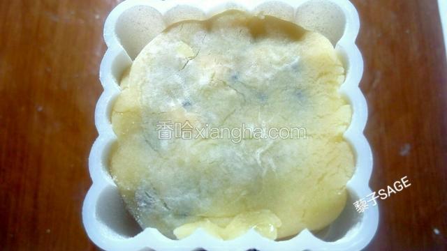 将裹好面粉的面团放入模具中，用手指轻柔均匀的按压，把面团压平压实。 