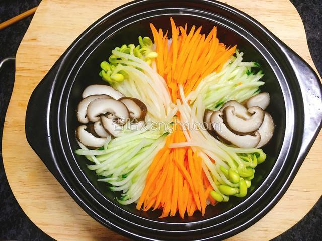 把黄瓜、胡萝卜、黄豆芽、香菇有序的铺在饭上。