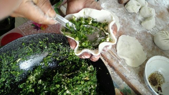 把剂子擀成中间稍厚边上薄的圆片。往圆片里放上馅儿，像包包子那样包起来。