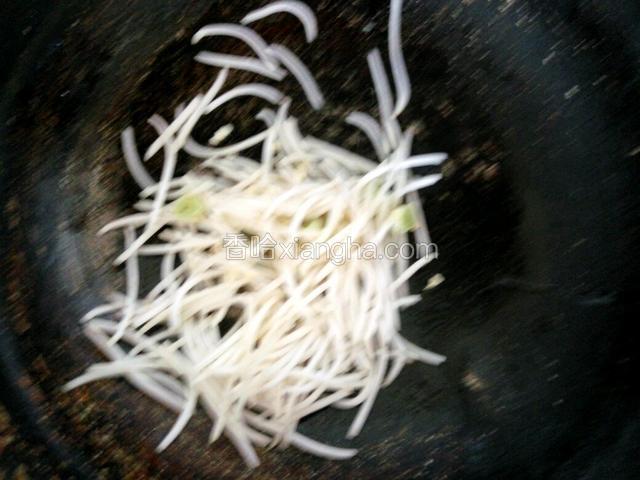 锅中倒油，爆香葱蒜，放绿豆芽大火快炒