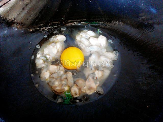 锅中加少量的油放入蒜，辣椒煸香后加入海蛎，并打入一个鸡蛋