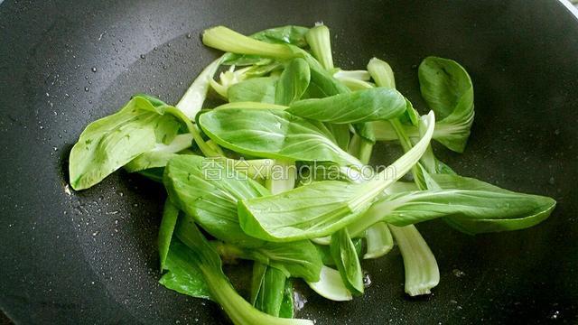 另起锅放适量油烧热后，把小青菜放入锅中快速炒软。