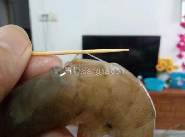 用剪刀将虾背剪开，用牙签挑开虾线。