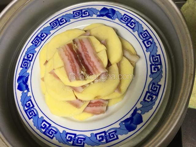 土豆咸肉入蒸锅中蒸；