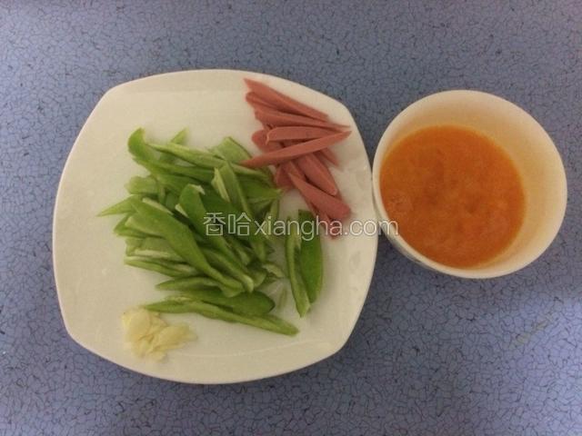 如图把青椒，火腿肠炒小块，蒜切片，鸡蛋放入少许料酒和盐打散打均匀后备用。