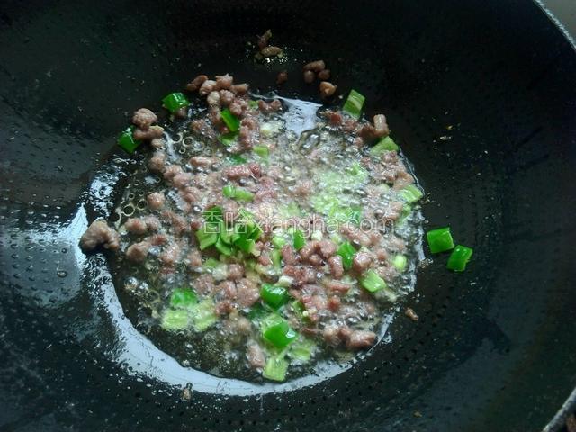 肉丁变小，放入葱花，姜末，辣椒，生抽煸炒出香味。