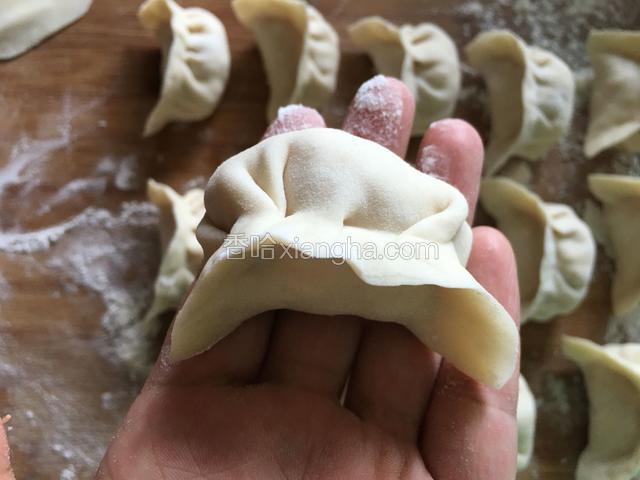 将皮捏紧，一个饺子生坯就做好啦。